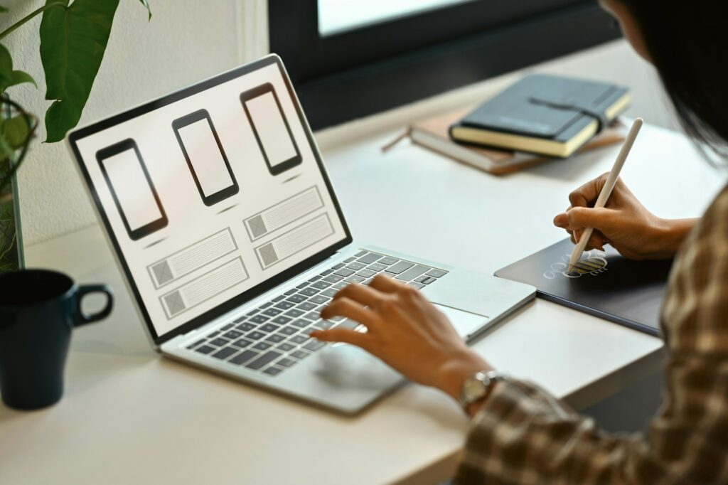 Female website developer planning application development for web mobile phone at workplace.